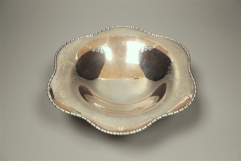 A circular silver tazza having shaped edge, engraved honeysuckle decoration and oval paterae Atkin Brothers, Sheffield, 1910,